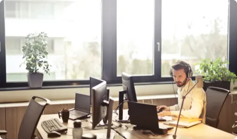 Man working in an office with a headset on